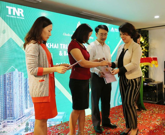Bà Hồ Thị Thanh Thủy - Giám đốc Trung tâm Dịch vụ khách hàng và Quản lý sản phẩm GoldSilk trao sổ đỏ tới đại diện cư dân khu liền kề.