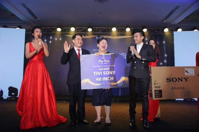 Ca sĩ Đan Trường và đại diện Vạn Thái Land trao giải nhất cho KH trúng giải nhất vòng quay may mắn trong đêm Gala.