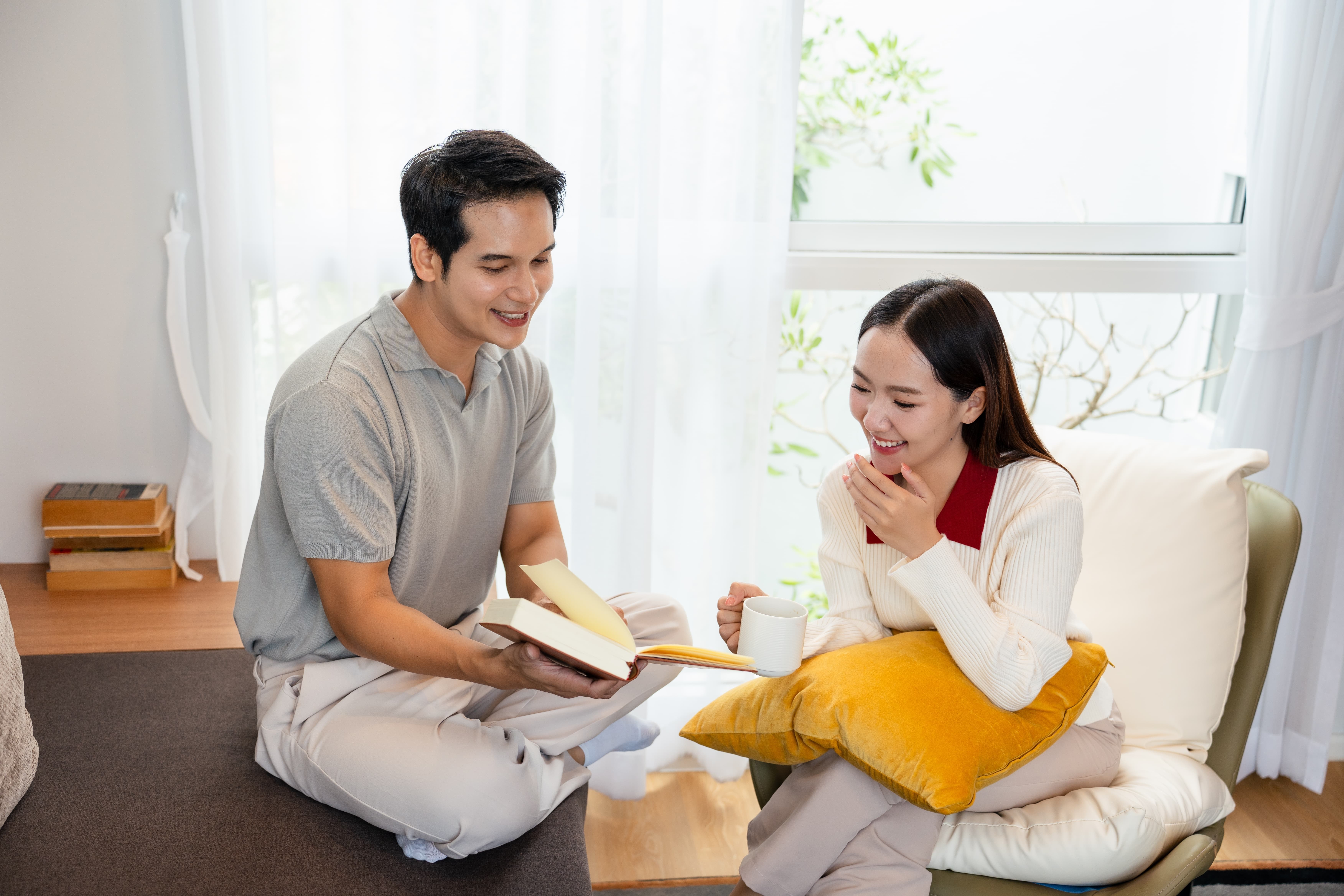 Đôi bạn trẻ đọc sách bên cửa sổ