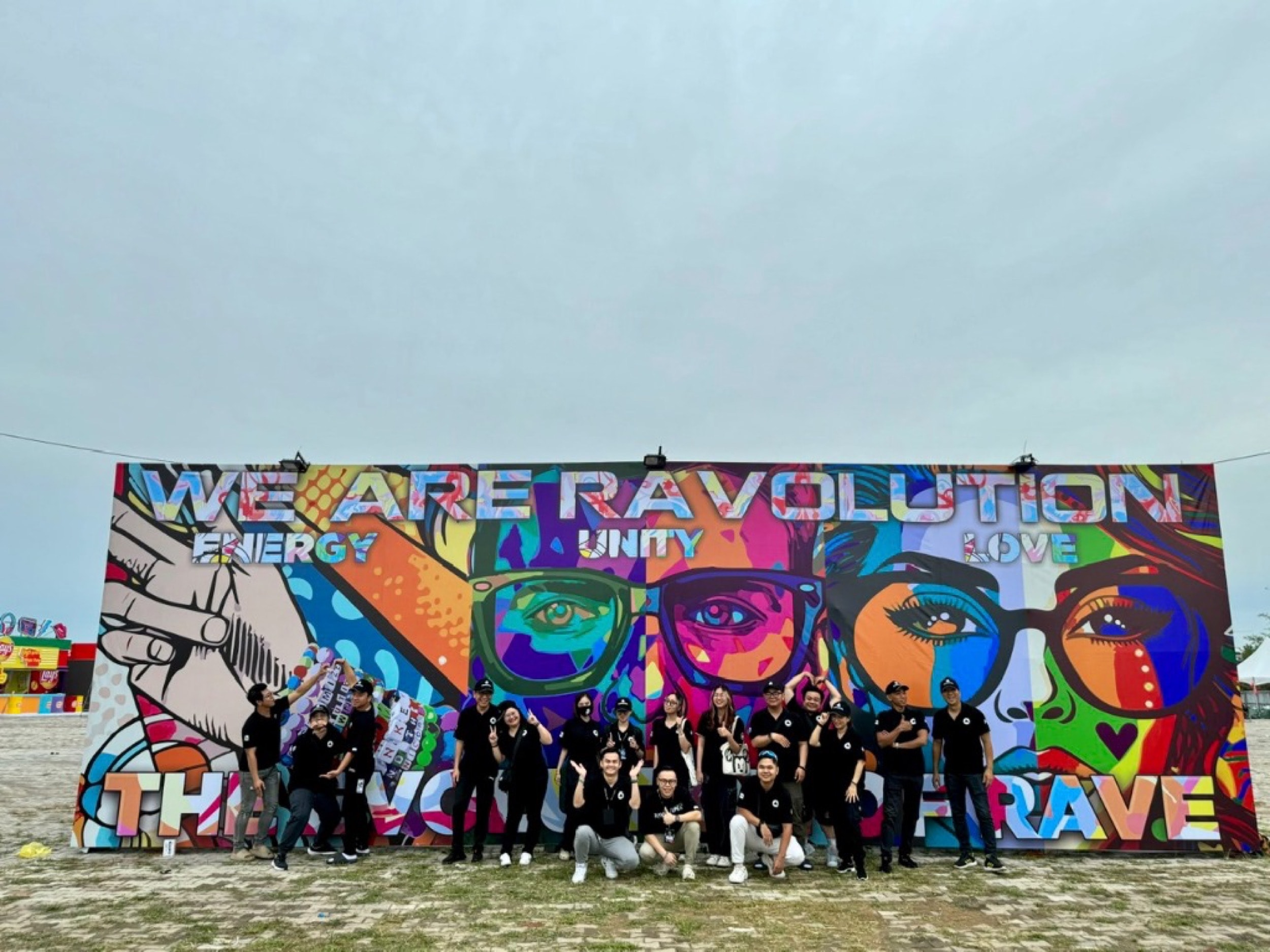 Tập thể ban tổ chức và cộng đồng ravers đứng trước bảng hiệu We Are Ravolution