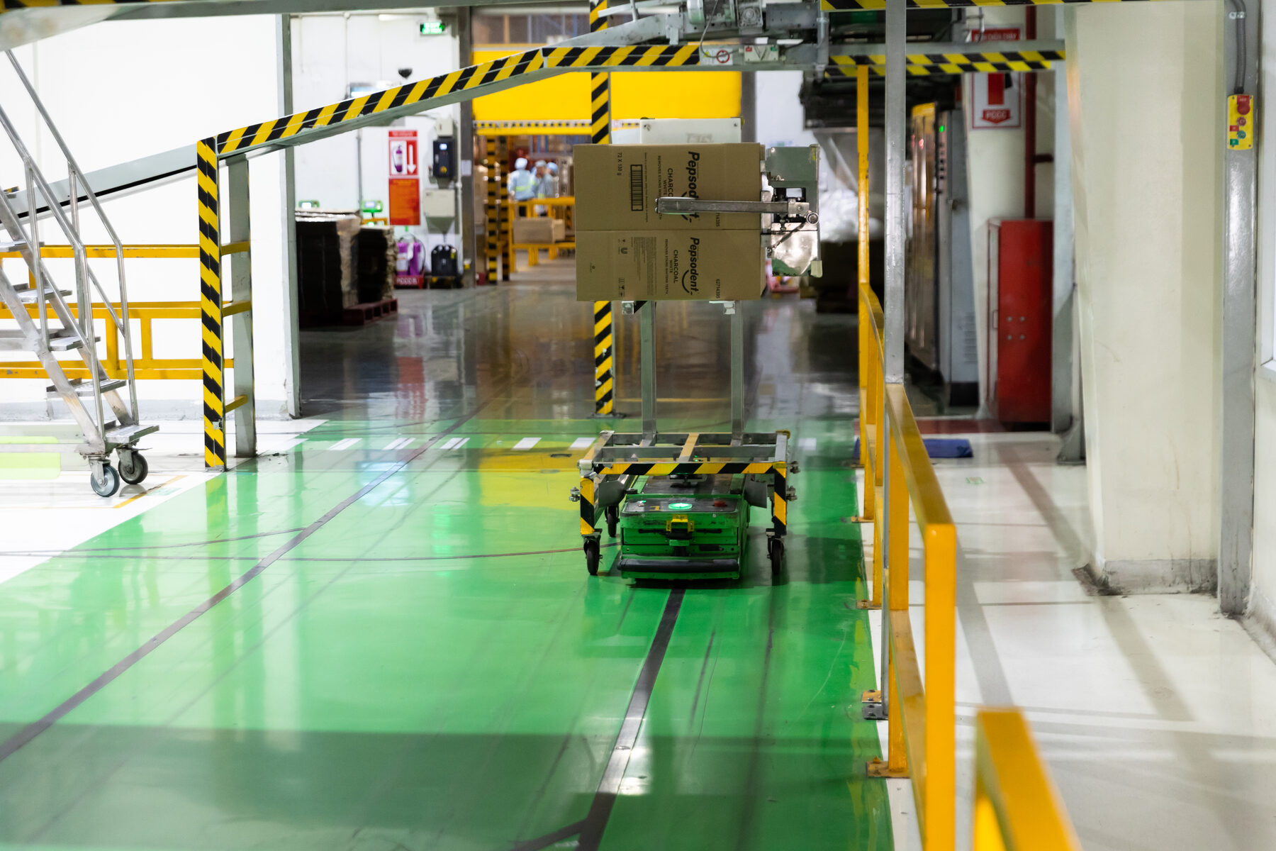 Robot tự h&agrave;nh vận chuyển c&aacute;c th&ugrave;ng sản phẩm kem đ&aacute;nh răng, b&aacute;m theo vạch sơn đen